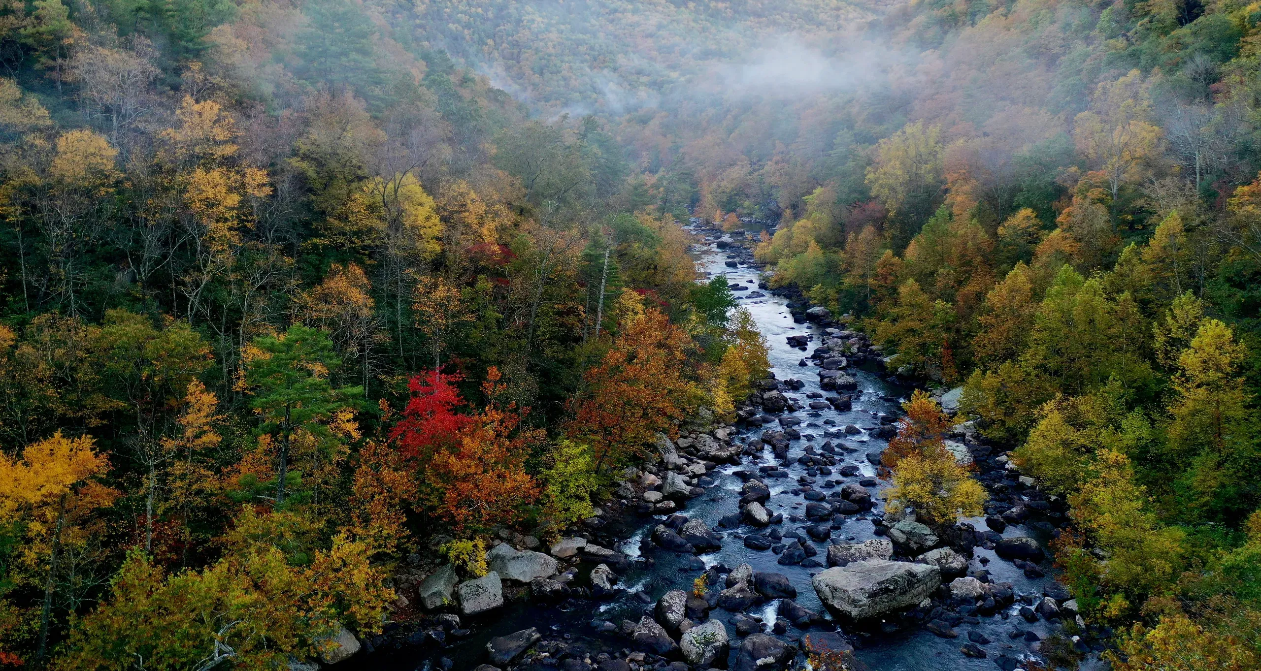 Goshen, Virginia. River runs through fall trees in valley with clouds