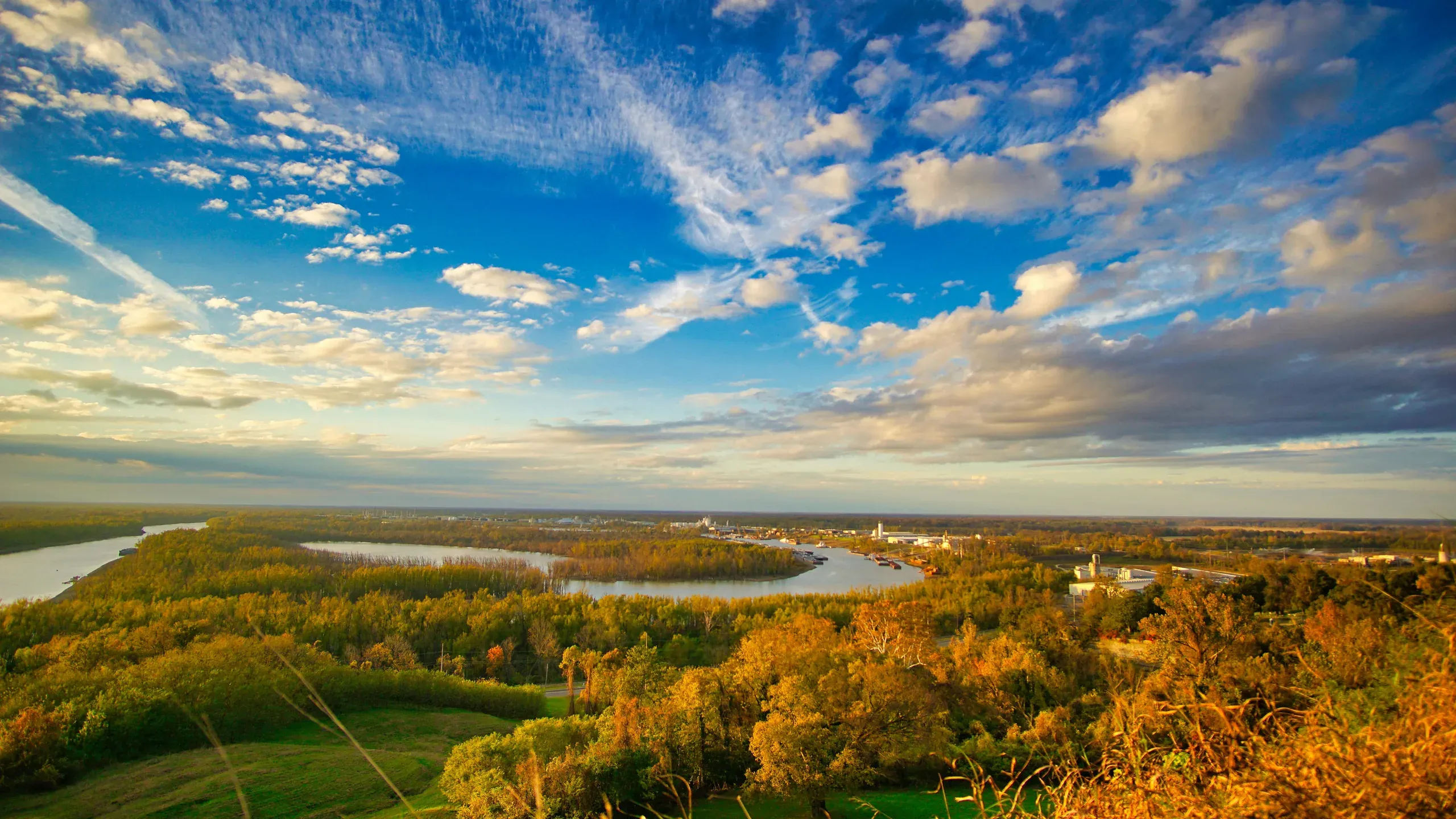 Vicksburg, Mississippi. Autumnal trees near the body of water under the blue sky and white clouds