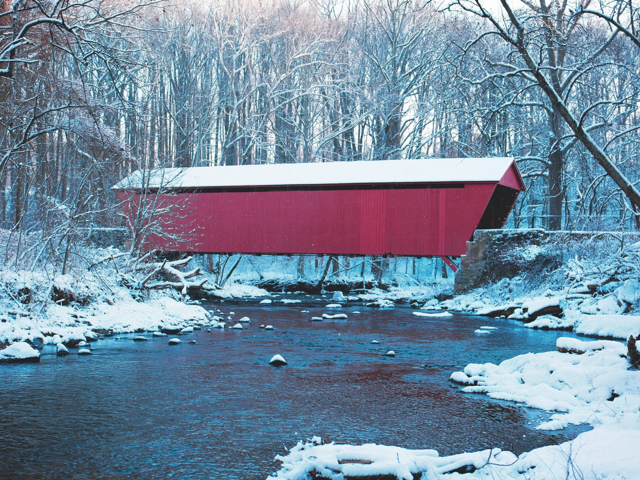 Kingsville, Maryland. A red, wooden, roofed bridge across a river