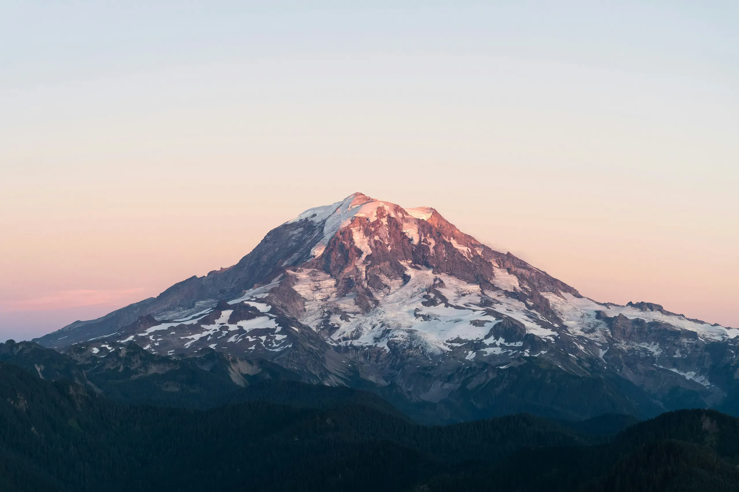 Mt. Rainier (also known as Tahoma or Tacoma), Washington softly glows blue and red on the evening of September 6th, 2020. This is the northwestern slope seen from the window of a Cessna 172 light aircraft. In the late summer the mountain's ice and snow is at a season low.