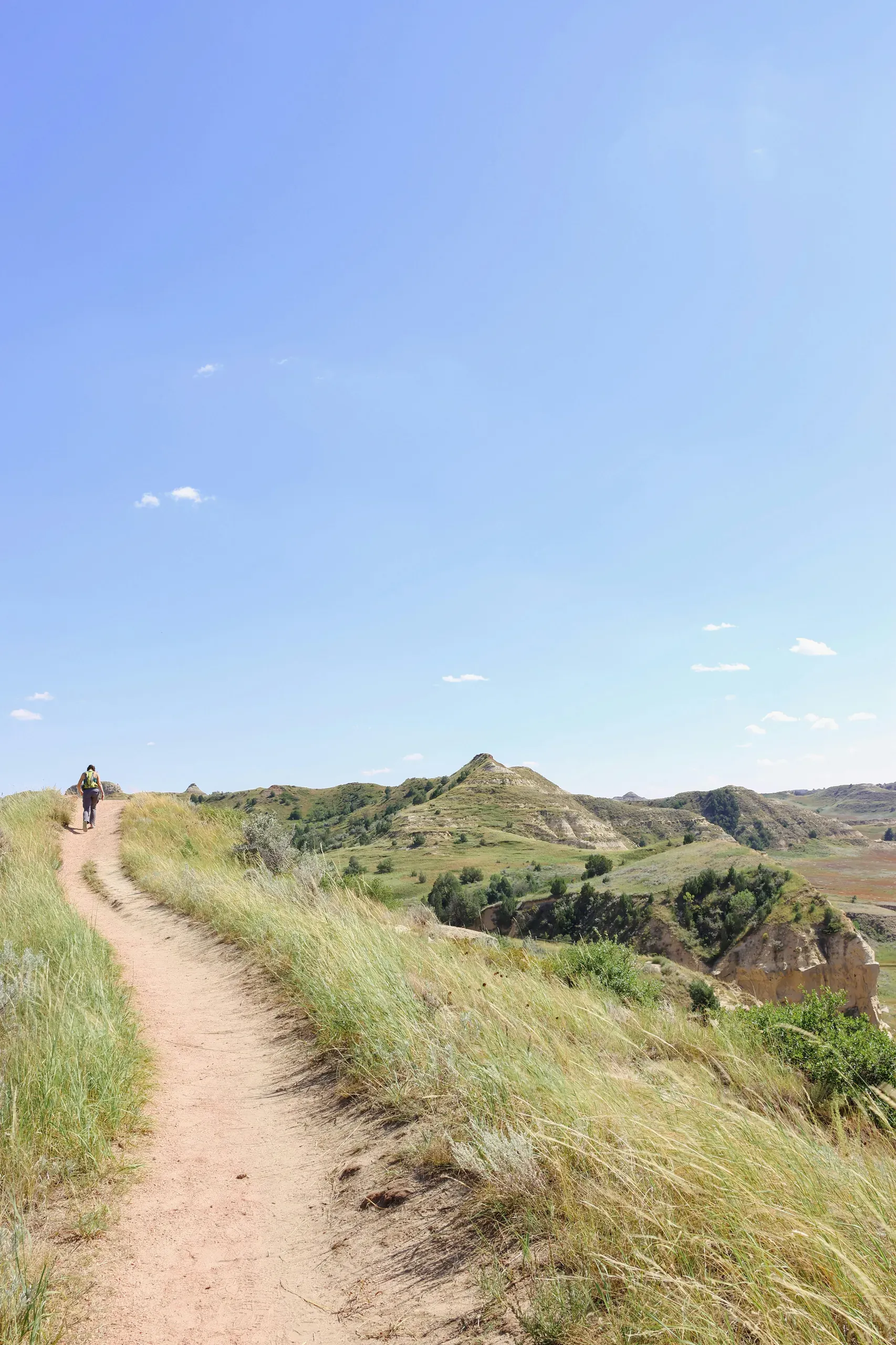 Watford City, North Dakota. A person hiking on a trail in the distance