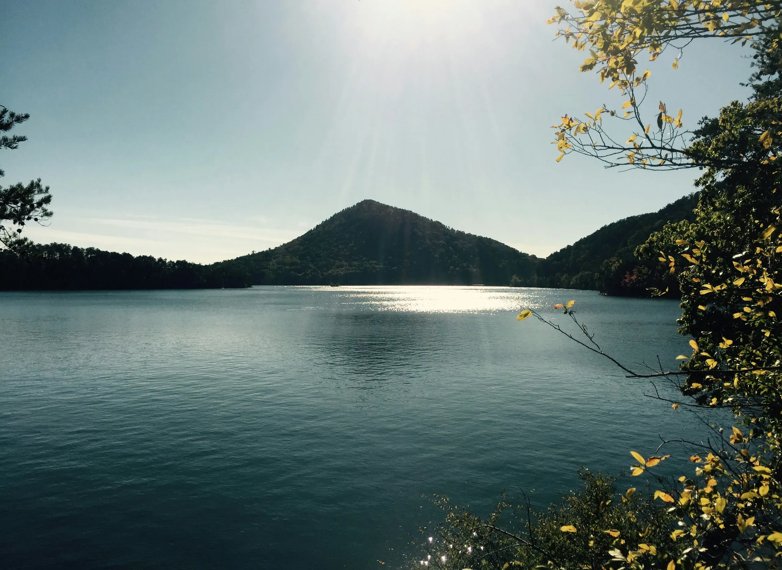 Lake Ocoee, Tennessee. Sunshine and sun rays on mountain and blue lake with autumn leaves