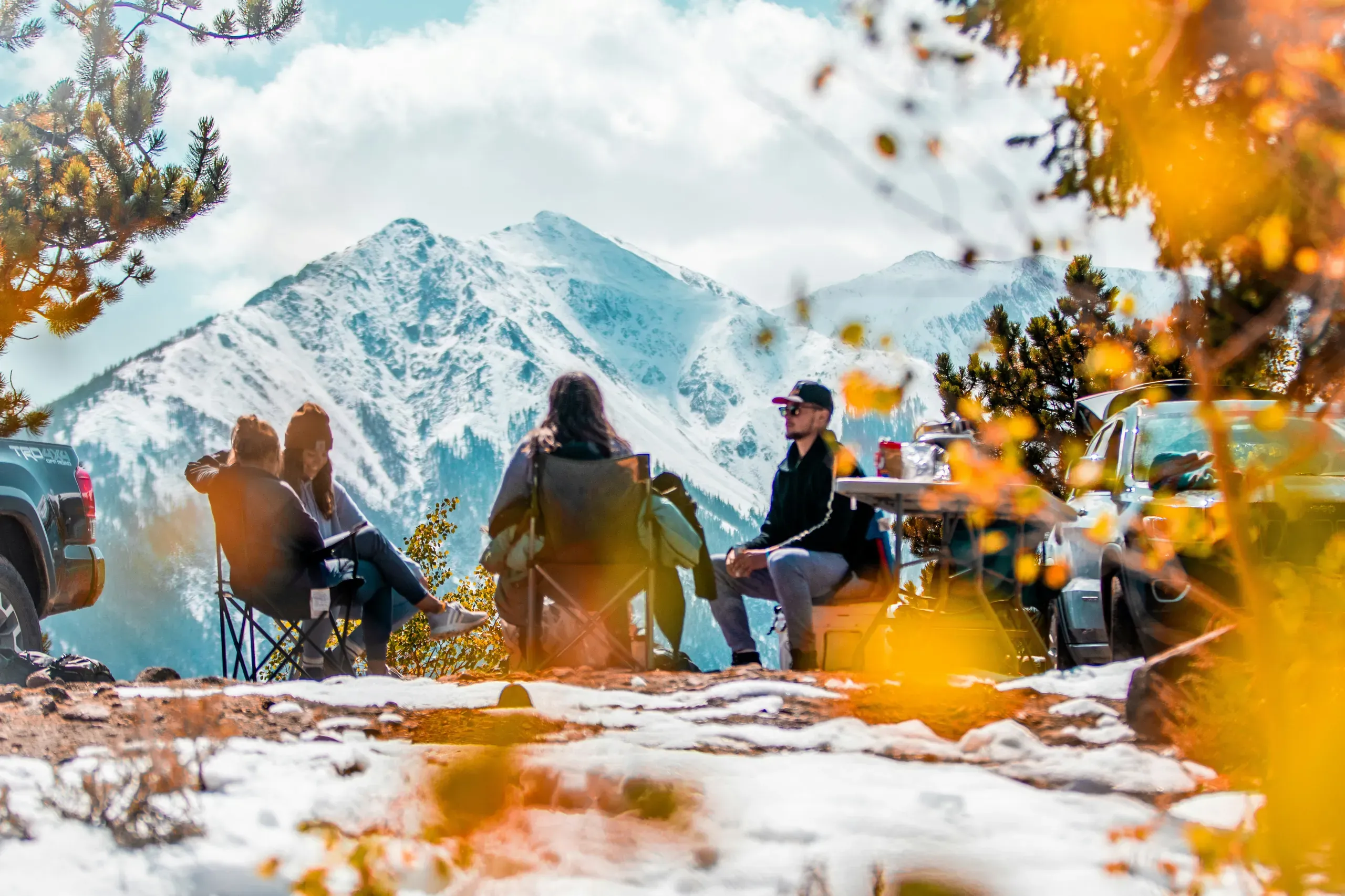 Twin Lakes, Colorado. Friends sitting around campsite with epic mountain view in colorado fall.