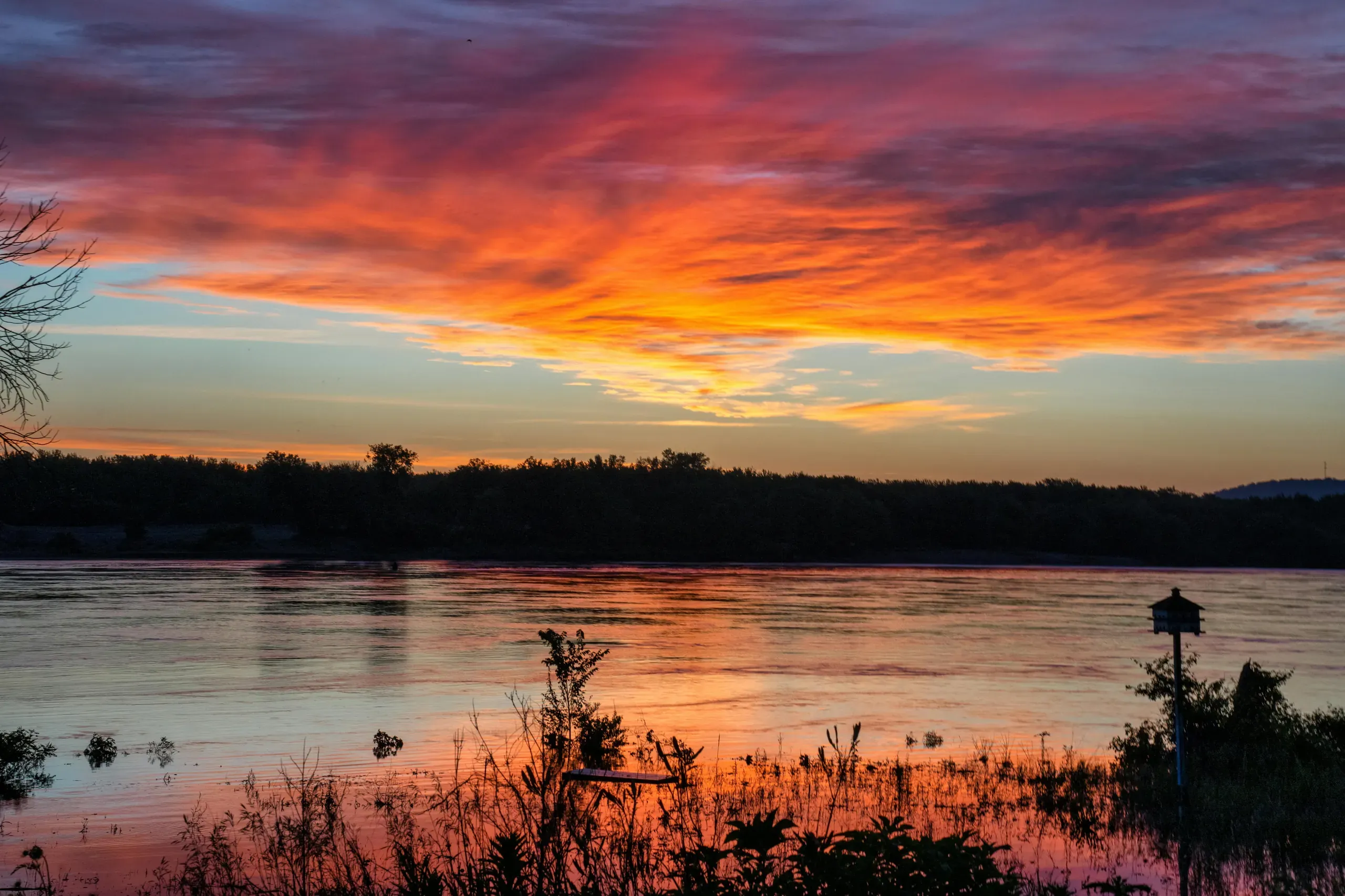 Reads Landing, Mississippi. A sunset over the river with clouds and grass