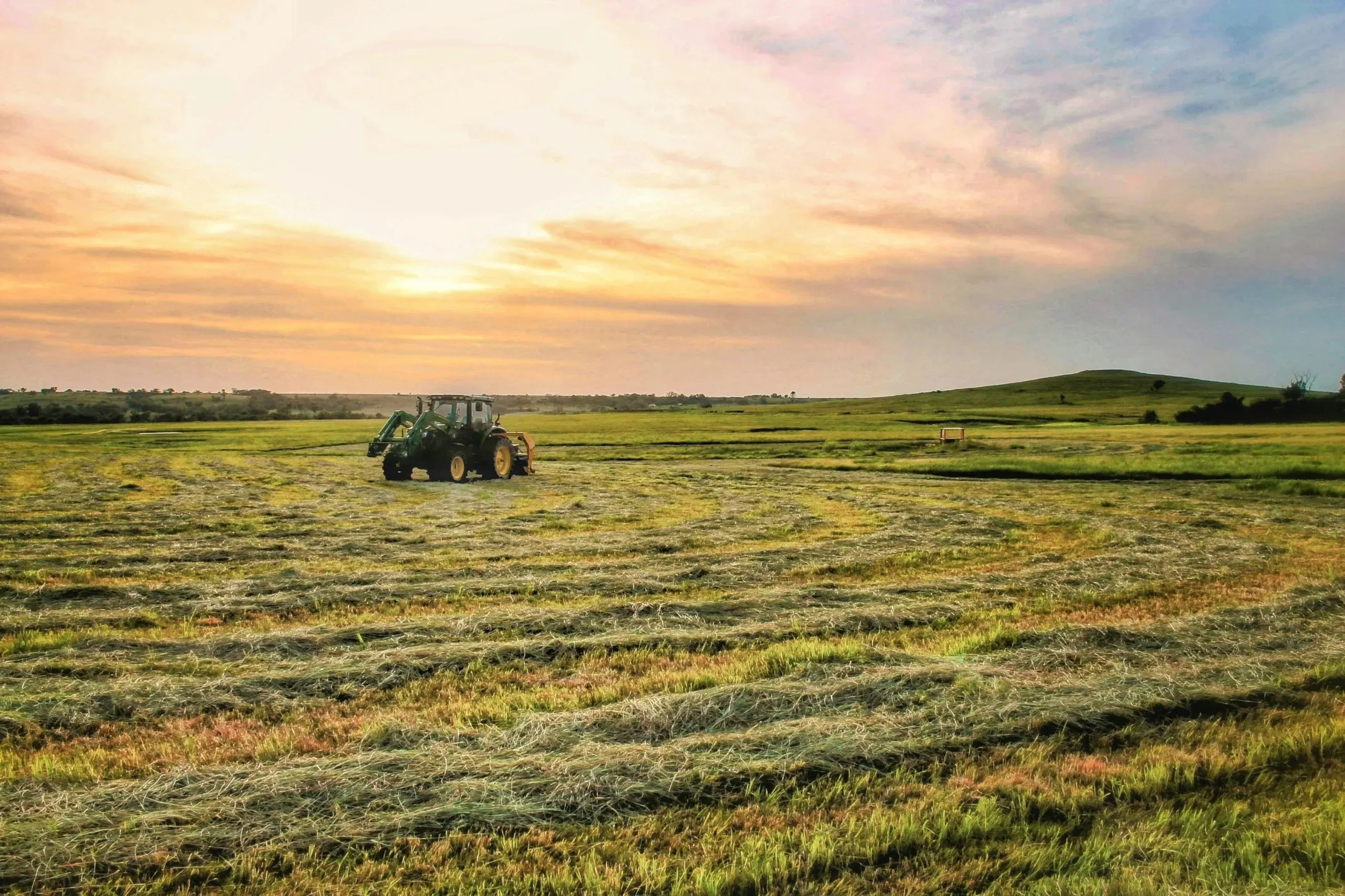 Eureka, Kansas. Tractor on field under clouds.