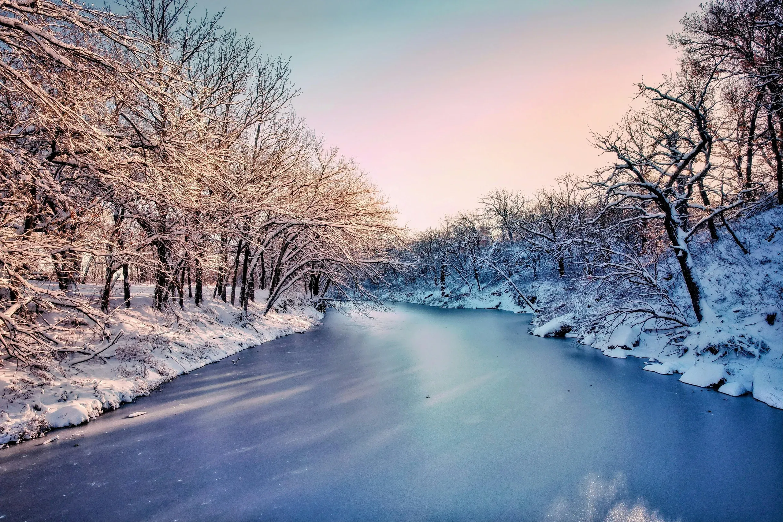 Eureka, Kansas. View of a frozen body of water between snowy trees.