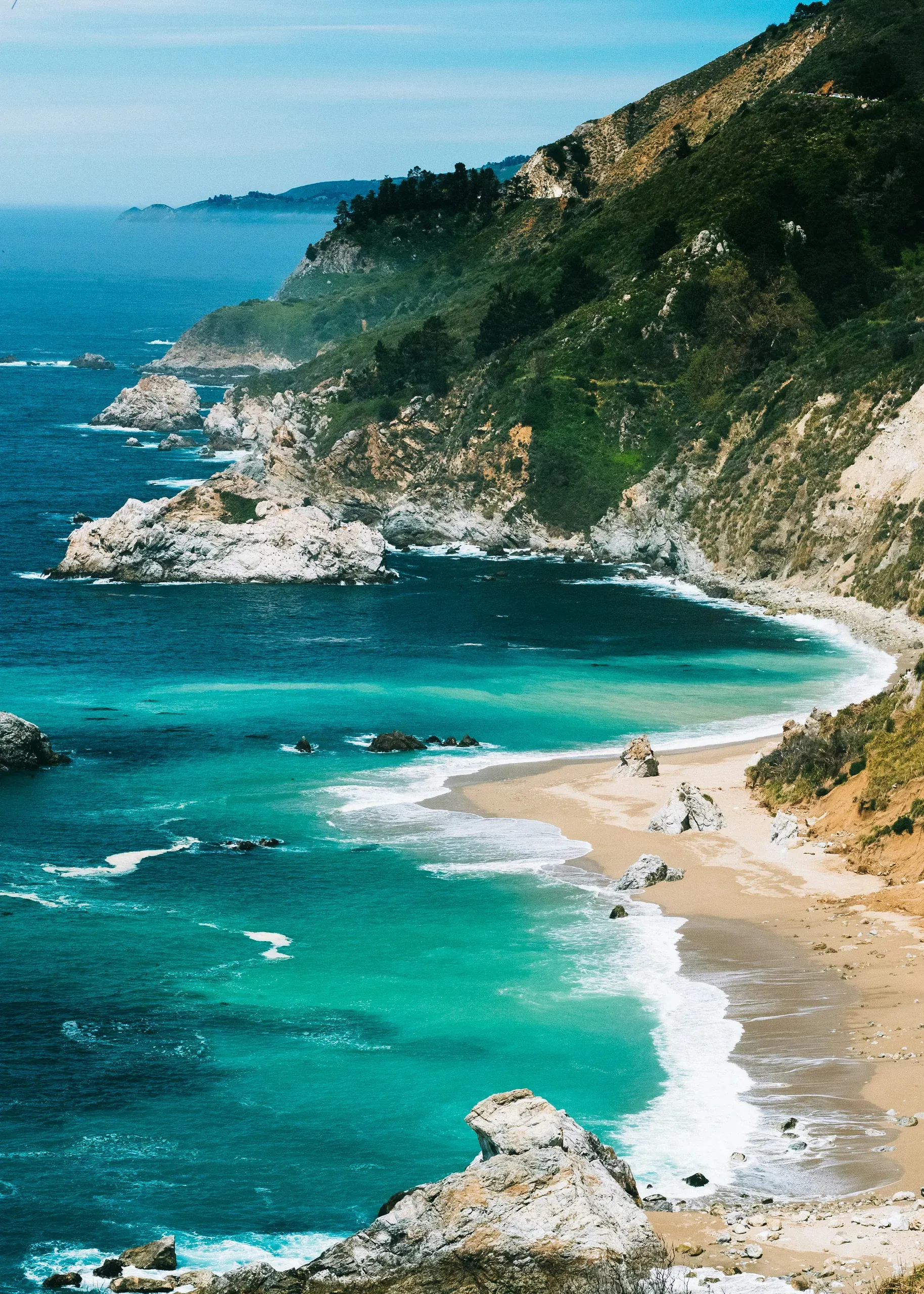 The Californian Coast with green ocean water and sandy beaches.