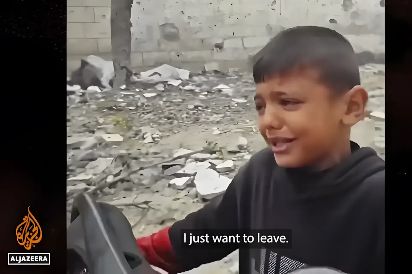 Al Jazeera footage of a young boy amid rubble in Gaza, subtitled 'I just want to leave.'