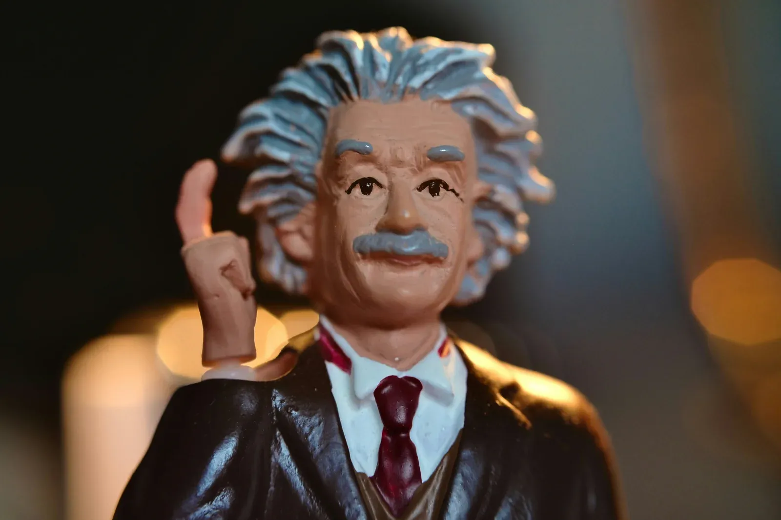 Close-up of an Albert Einstein figurine with wild hair, giving a thumbs up