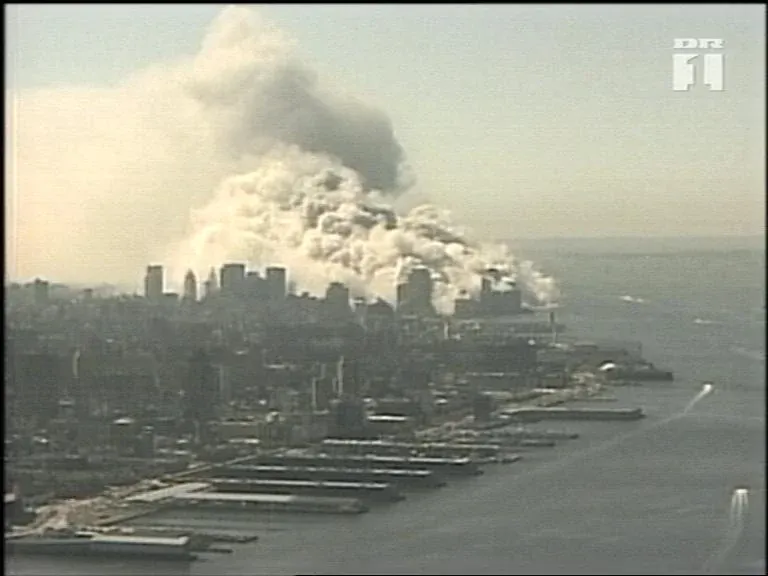 Aerial view of lower Manhattan with massive dust clouds billowing from the World Trade Center collapse site, DR1 Danish television watermark visible