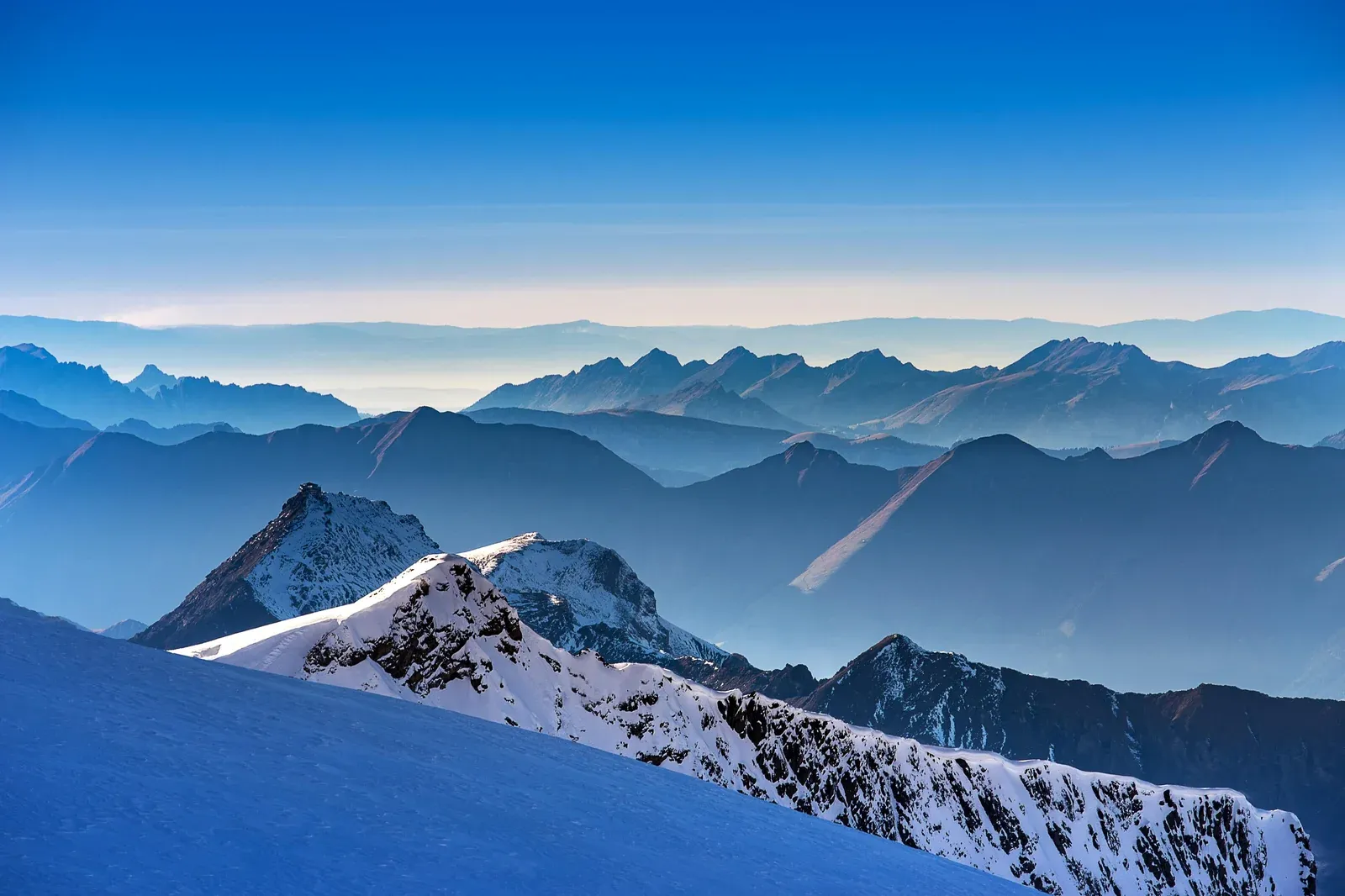 Snow-covered Alpine peaks and ridges stretching into blue haze above Lauterbrunnen, Switzerland
