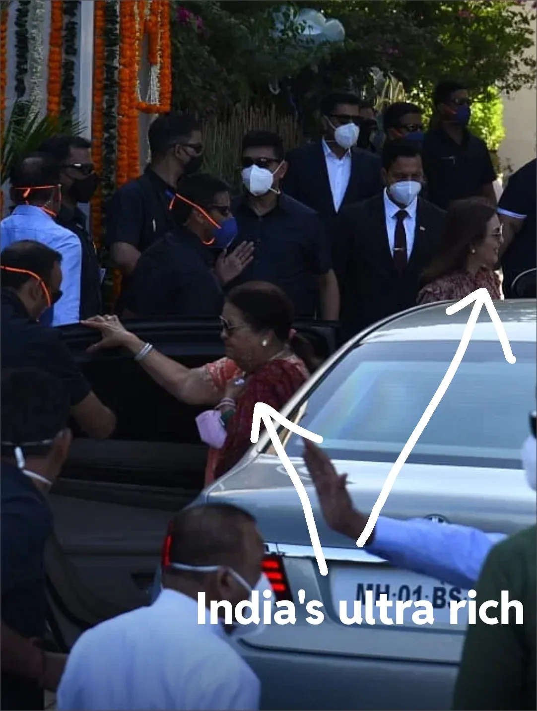 Photo from India showing wealthy people unmasked while staff and security wear masks, white arrows labelled India's ultra rich highlighting the double standard