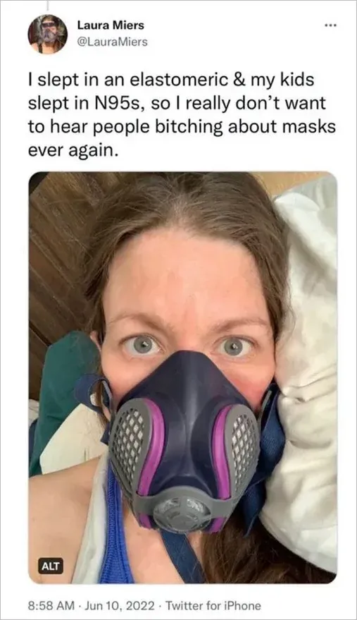 Tweet from Laura Miers @LauraMiers (Jun 10 2022): I slept in an elastomeric and my kids slept in N95s, so I really don't want to hear people bitching about masks ever again. Selfie wearing purple elastomeric respirator in bed