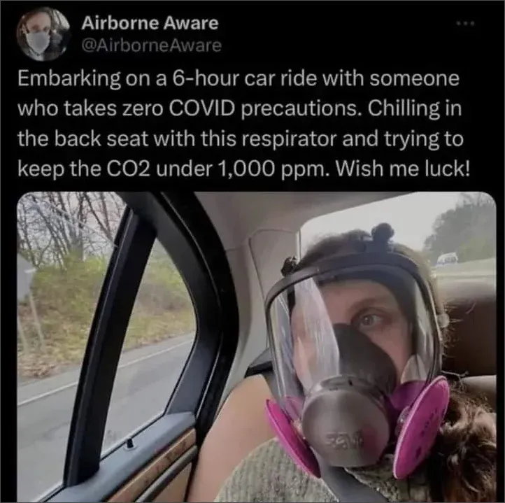 Tweet from @AirborneAware: Embarking on a 6-hour car ride with someone who takes zero COVID precautions, chilling in the back seat with this respirator and trying to keep the CO2 under 1000 ppm. Selfie wearing full-face respirator with pink filters