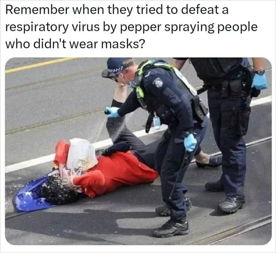 Meme captioned Remember when they tried to defeat a respiratory virus by pepper spraying people who didn't wear masks showing Australian police pepper-spraying a person lying on the ground holding an Australian flag