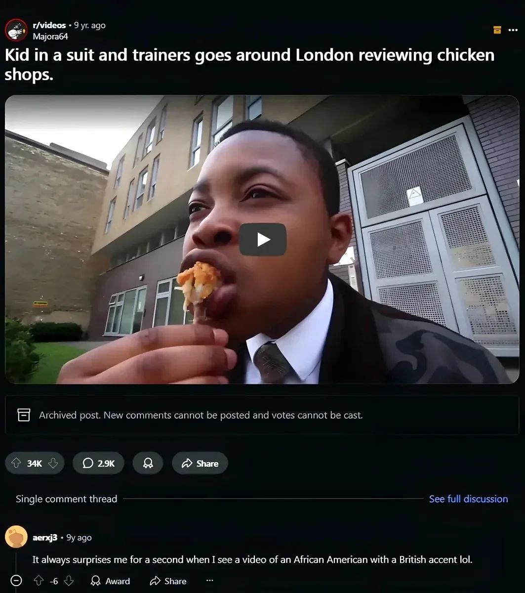 Reddit post from r/videos by Majora64 (9 yr. ago). Title: "Kid in a suit and trainers goes around London reviewing chicken shops." Video thumbnail shows a young Black man in a suit eating chicken outside a London building. archived. Comment from aerxj3 (9y ago, -6 votes): "It always surprises me for a second when I see a video of an African American with a British accent lol."