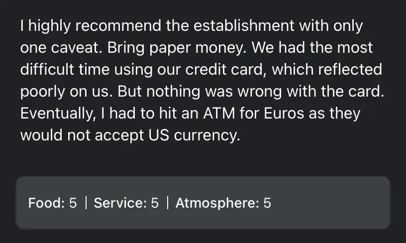 Restaurant review. Text: "I highly recommend the establishment with only one caveat. Bring paper money. We had the most difficult time using our credit card, which reflected poorly on us. But nothing was wrong with the card. Eventually, I had to hit an ATM for Euros as they would not accept US currency." Rating box below: "Food: 5 | Service: 5 | Atmosphere: 5"
