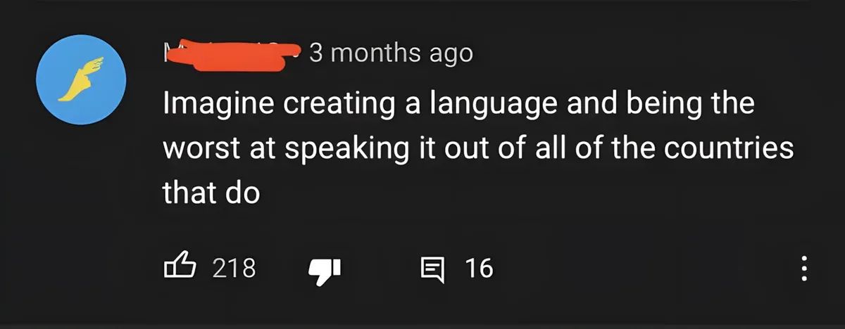 YouTube comment (username redacted, blue hand-waving avatar, 3 months ago): "Imagine creating a language and being the worst at speaking it out of all of the countries that do"
