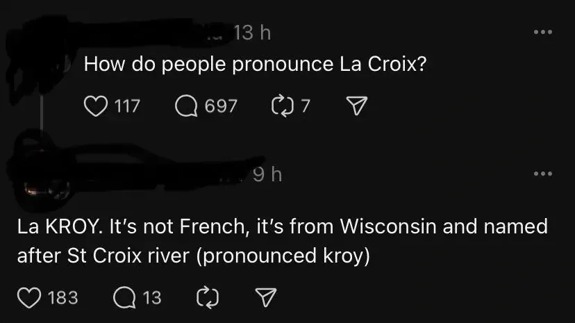Threads/Instagram post thread. First post (username redacted, 13h): "How do people pronounce La Croix?" Reply (username redacted, 9h): "La KROY. It's not French, it's from Wisconsin and named after St Croix river (pronounced kroy)"