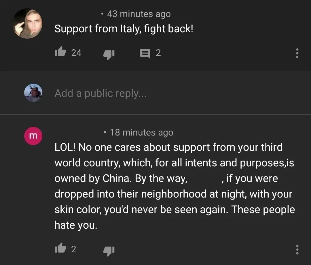 YouTube comment thread. First comment (43 minutes ago): "Support from Italy, fight back!" Add a public reply (windmill avatar). Reply (pink 18 minutes ago): "LOL! No one cares about support from your third world country, which, for all intents and purposes, is owned by China. By the way, [redacted], if you were dropped into their neighborhood at night, with your skin color, you'd never be seen again. These people hate you." Three-dot menu