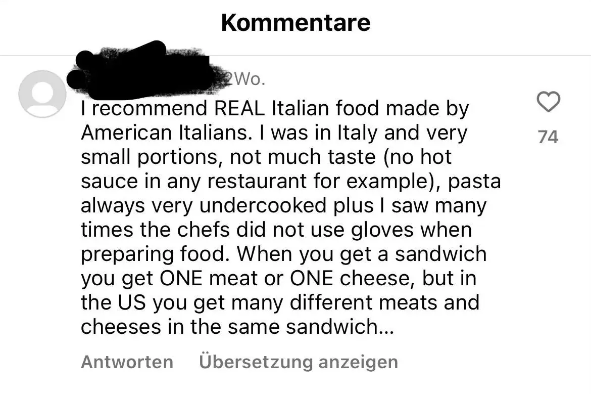 TikTok/Instagram comment with German-language interface ("Kommentare" header, "Antworten", "Ubersetzung anzeigen"). Username scribbled out, grey 2Wo. (2 weeks). Text: "I recommend REAL Italian food made by American Italians. I was in Italy and very small portions, not much taste (no hot sauce in any restaurant for example), pasta always very undercooked plus I saw many times the chefs did not use gloves when preparing food. When you get a sandwich you get ONE meat or ONE cheese, but in the US you get many different meats and cheeses in the same sandwich..." Antworten, Ubersetzung anzeigen