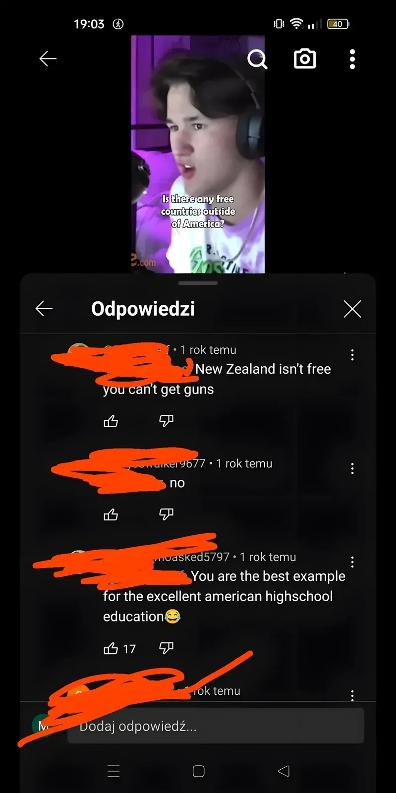 YouTube comment thread on mobile with Polish-language interface ("Odpowiedzi", "Dodaj odpowiedz..."). Video thumbnail showing young man with headphones, text overlay: "Is there any free countries outside of America?" Three replies (username redacted, 1 rok temu/1 year ago): First: "New Zealand isn't free you can't get guns". Second (walker9677): "no". Third (moasked5797): "You are the best example for the excellent american highschool education" with laughing emoji