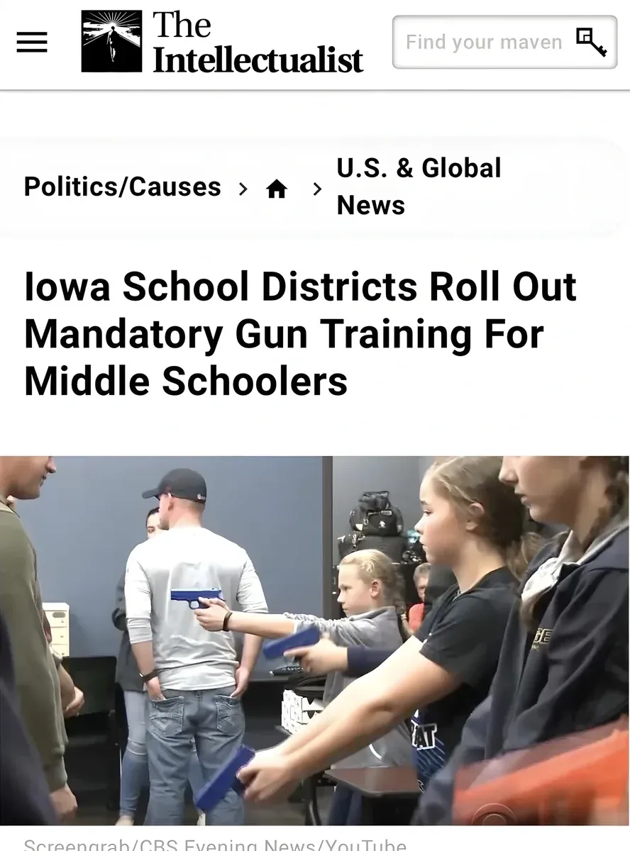 Screenshot of a news article from The Intellectualist website. Category: Politics/Causes > U.S. & Global News. Headline: "Iowa School Districts Roll Out Mandatory Gun Training For Middle Schoolers". Photo shows children in a classroom setting with an adult instructor in baseball cap demonstrating with a blue training gun while a young girl holds one. Credit: Screengrab/CBS Evening News/YouTube