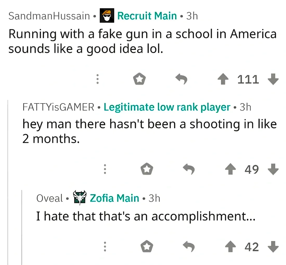 Reddit comment thread from a gaming subreddit (Rainbow Six Siege based on flairs). SandmanHussain (Recruit Main, 3h): "Running with a fake gun in a school in America sounds like a good idea lol." FATTYisGAMER (Legitimate low rank player, 3h): "hey man there hasn't been a shooting in like 2 months." Oveal (Zofia Main, 3h): "I hate that that's an accomplishment..."