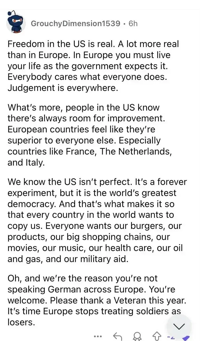 Reddit comment by GrouchyDimension1539 (6h, -2 downvotes). Long comment claiming freedom in the US is more real than in Europe, that every country wants to copy America and wants "our burgers, our products, our big shopping chains, our movies, our music, our health care, our oil and gas, and our military aid." Ends with: "we're the reason you're not speaking German across Europe. You're welcome. Please thank a Veteran this year."