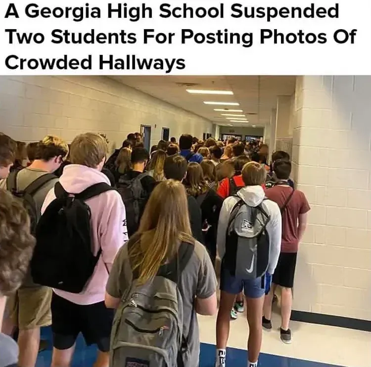 News article screenshot with photo. Bold headline: "A Georgia High School Suspended Two Students For Posting Photos Of Crowded Hallways". Photo shows a packed school hallway full of students with backpacks, shoulder to shoulder, barely able to move
