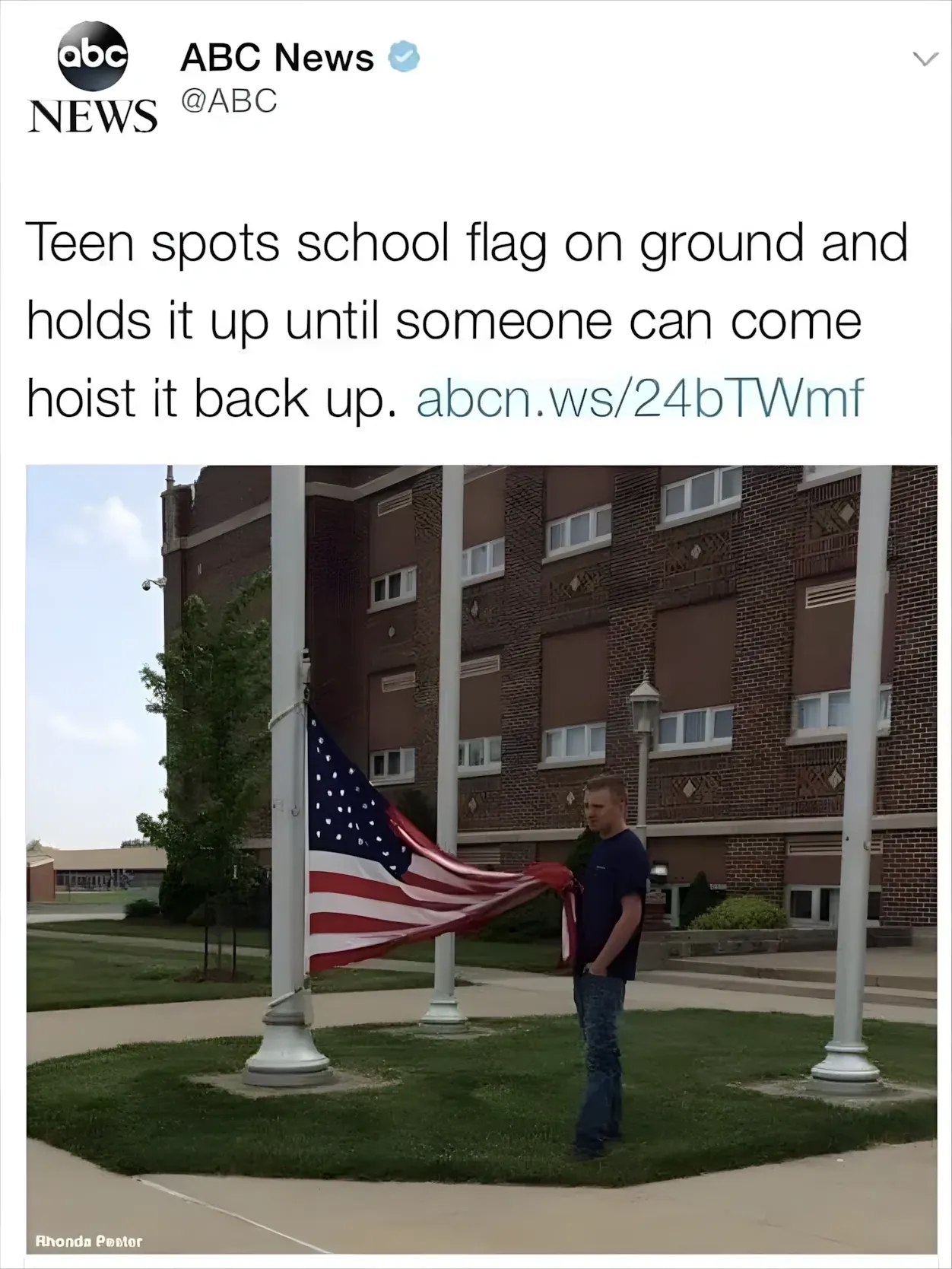 Twitter/X post by ABC News (@ABC, verified). Tweet: "Teen spots school flag on ground and holds it up until someone can come hoist it back up. abcn.ws/24bTWmf" Photo of a teen boy in dark clothing standing next to a flagpole outside a school building, holding up a large American flag. Credit: Rhonda Pester