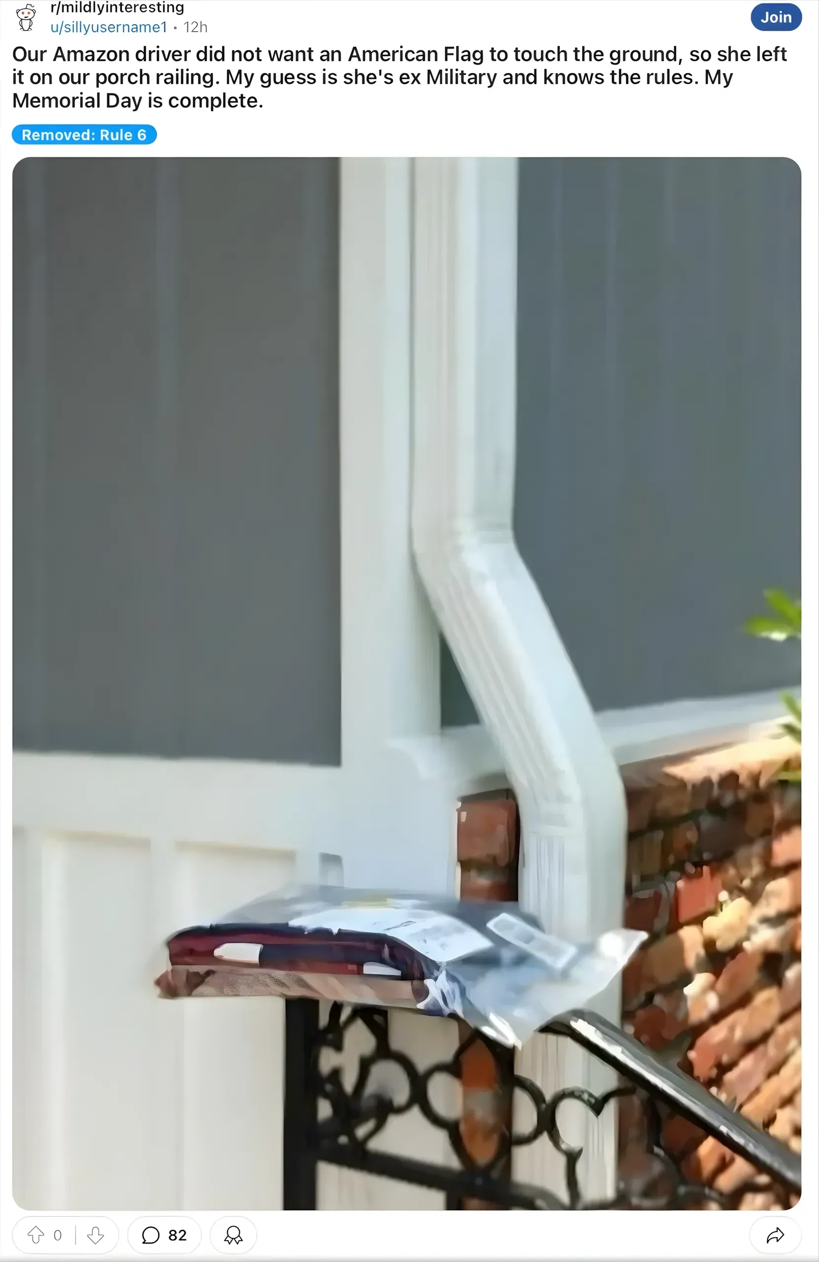Reddit post from r/mildlyinteresting (12h). Title: "Our Amazon driver did not want an American Flag to touch the ground, so she left it on our porch railing. My guess is she's ex Military and knows the rules. My Memorial Day..." Tagged "Removed: Rule 6". Photo showing an Amazon package balanced on a porch railing next to a downspout, placed there to avoid touching a flag.