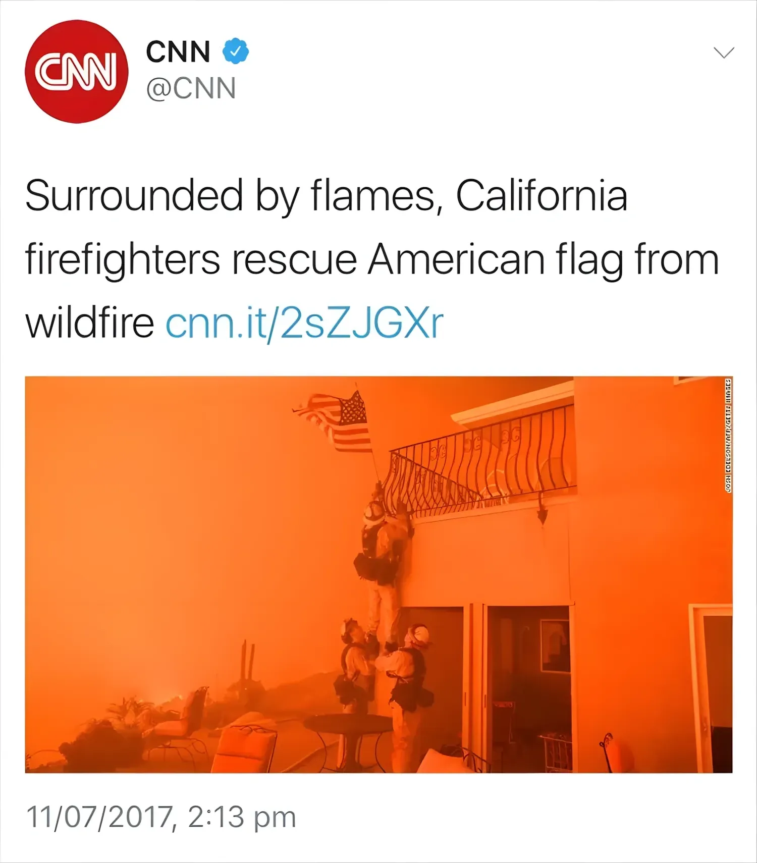 Twitter/X post by CNN (@CNN, verified). Tweet: "Surrounded by flames, California firefighters rescue American flag from wildfire cnn.it/2sZJGXr" Photo of firefighters against an orange flame-coloured sky reaching up to remove a flag from a building. 11/07/2017, 2:13 pm