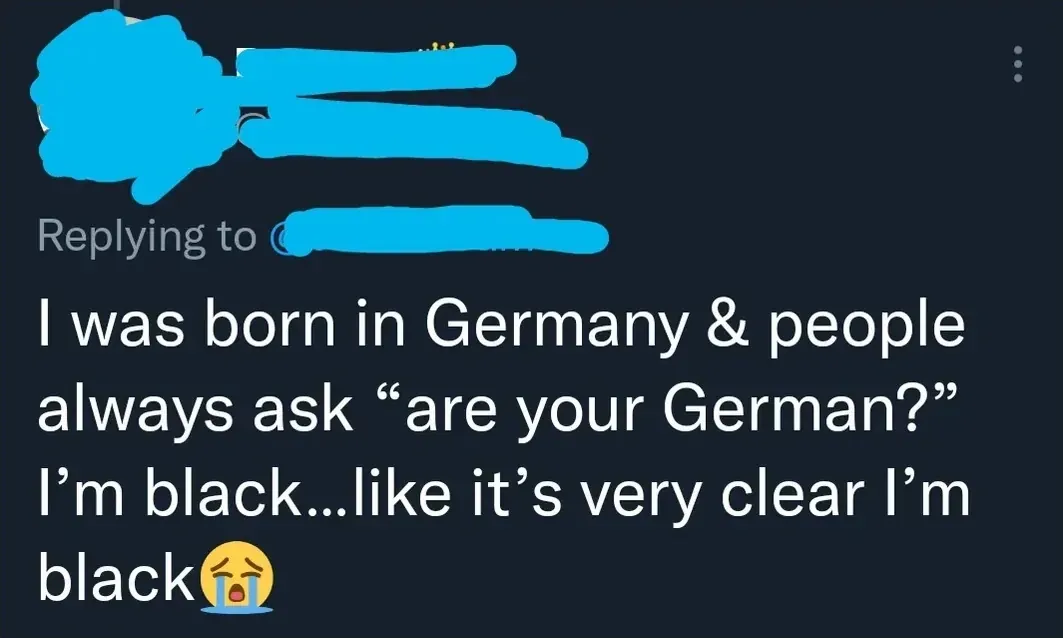 Twitter/X reply (username redacted). Comment: "I was born in Germany & people always ask 'are your German?' I'm black...like it's very clear I'm black" with crying emoji