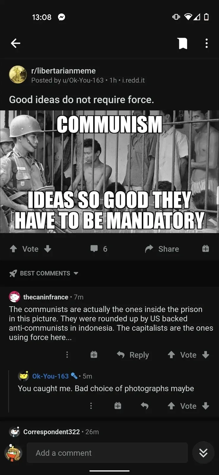 Reddit mobile app screenshot. r/libertarianmeme. Posted by u/Ok-You-163, 1h. Title: "Good ideas do not require force." Meme showing prisoners behind bars with text "COMMUNISM - IDEAS SO GOOD THEY HAVE TO BE MANDATORY". thecaninfrance (7m): "The communists are actually the ones inside the prison in this picture. They were rounded up by US backed anti-communists in indonesia. The capitalists are the ones using force here..." Ok-You-163 (5m): "You caught me. Bad choice of photographs maybe"