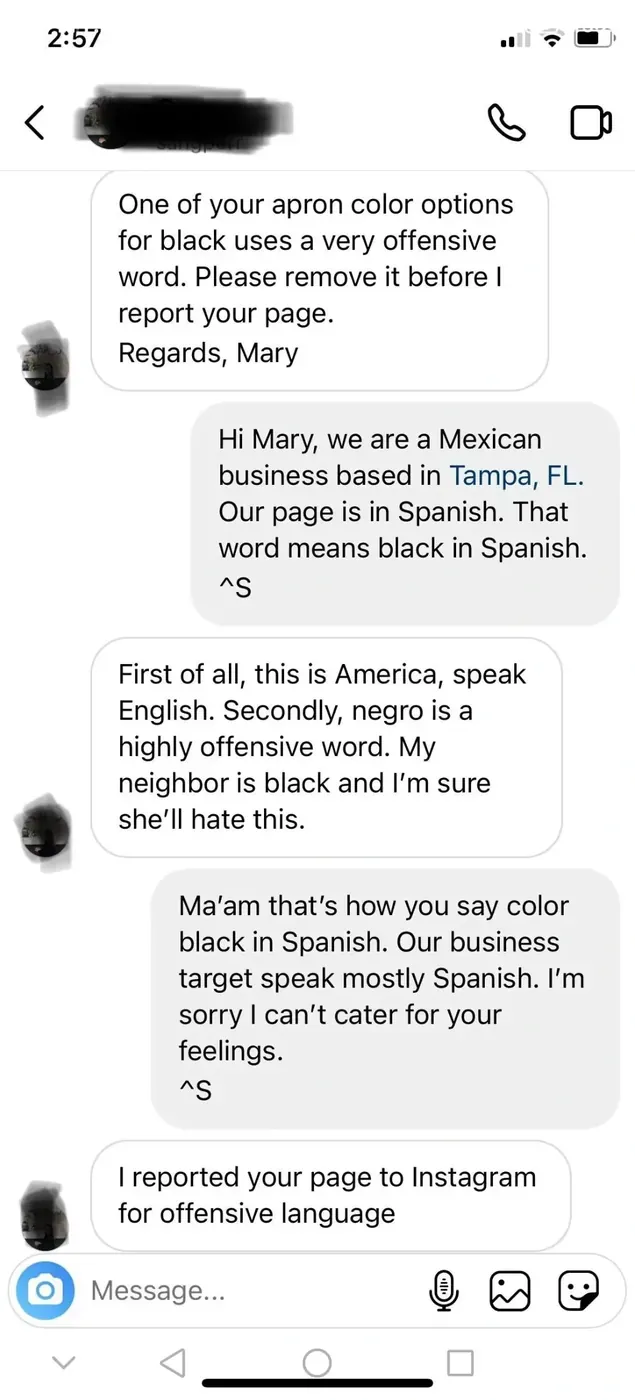 Instagram DM conversation. Customer Mary: "One of your apron color options for black uses a very offensive word. Please remove it before I report your page. Regards, Mary". Business reply (signed ^S): "Hi Mary, we are a Mexican business based in Tampa, FL. Our page is in Spanish. That word means black in Spanish." Mary: "First of all, this is America, speak English. Secondly, negro is a highly offensive word. My neighbor is black and I'm sure she'll hate this." Business: "Ma'am that's how you say color black in Spanish. Our business target speak mostly Spanish. I'm sorry I can't cater for your feelings." Mary: "I reported your page to Instagram for offensive language"