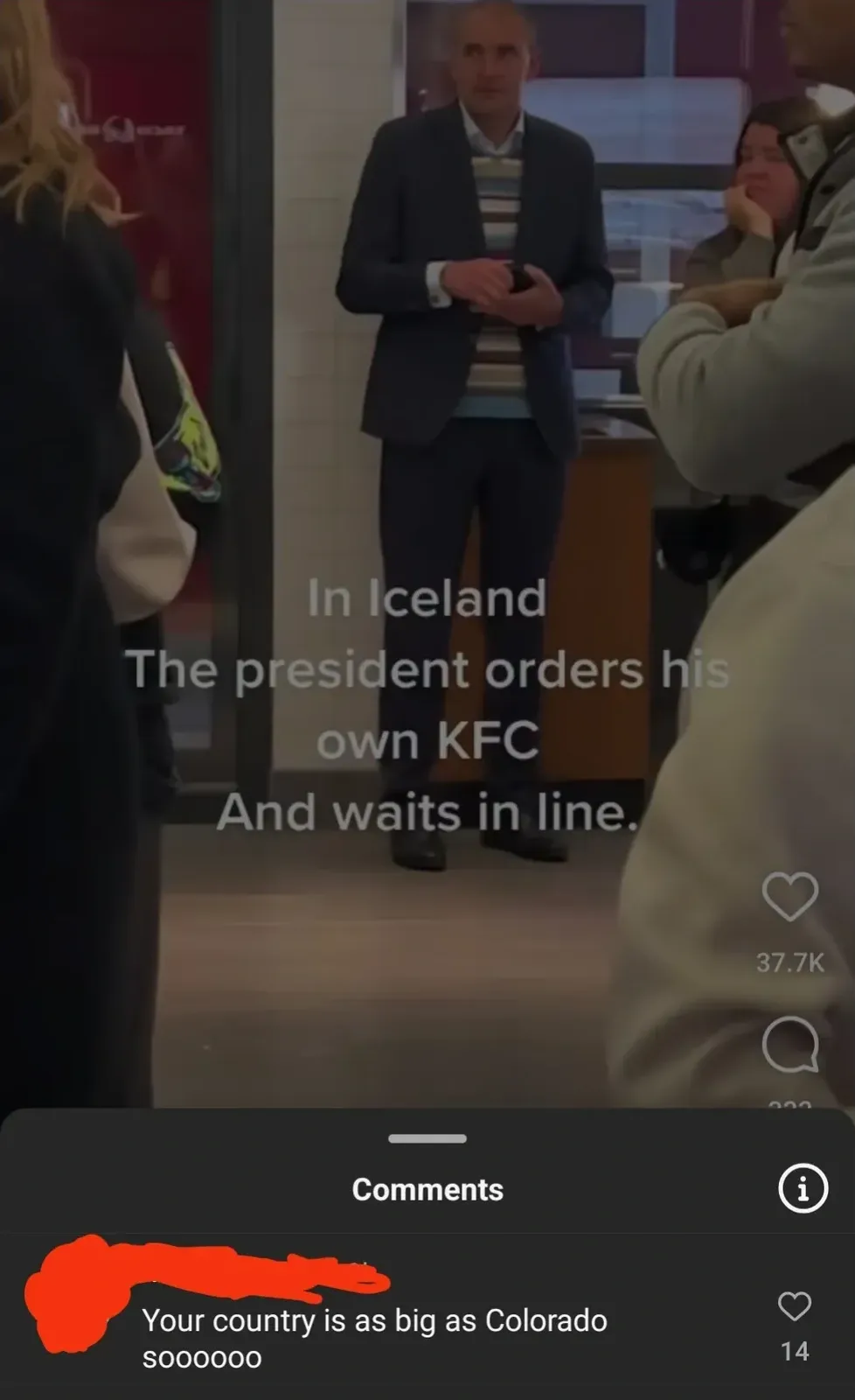 TikTok video showing a suited man standing casually among other customers in what appears to be a KFC, with text overlay: "In Iceland The president orders his own KFC And waits in line." Comment below (username redacted): "Your country is as big as Colorado soooooo"