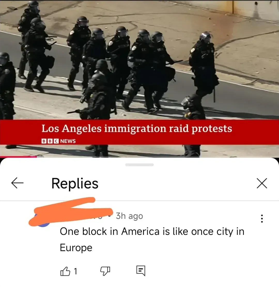 YouTube video screenshot showing BBC News coverage of "Los Angeles immigration raid protests" with riot police in full tactical gear marching down a street. Below, a Replies drawer with comment (username redacted, 3h ago): "One block in America is like once city in Europe"