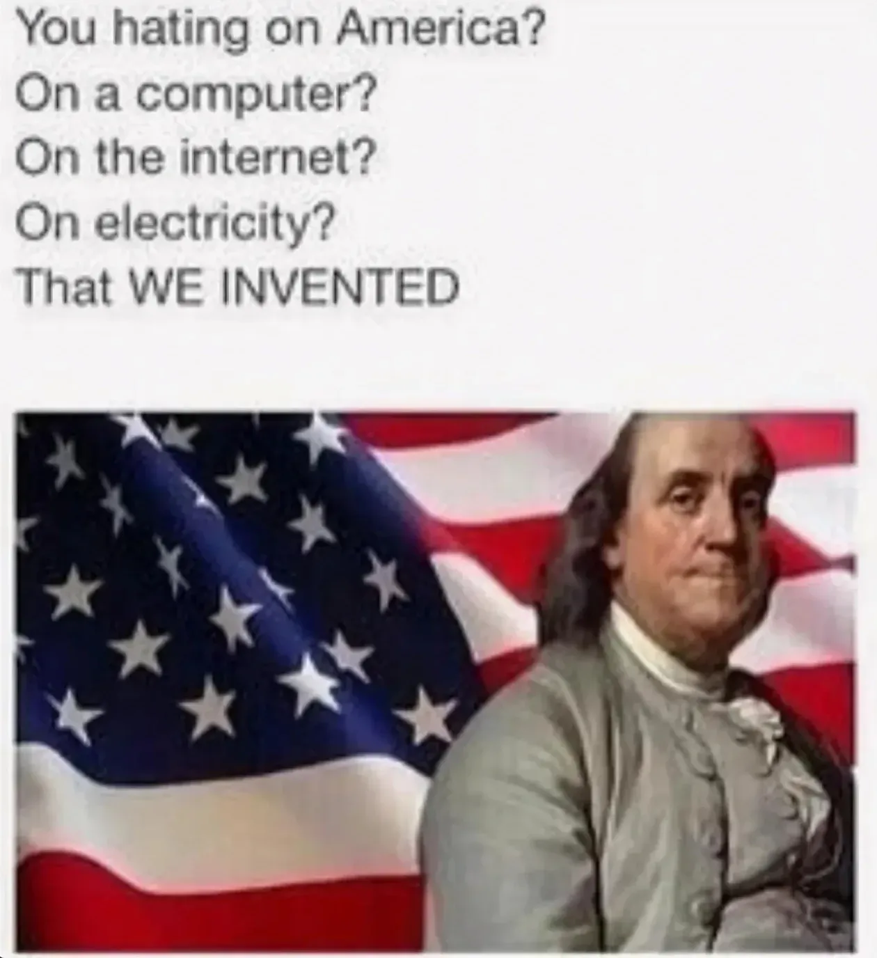 Meme. Text: You hating on America? On a computer? On the internet? On electricity? That WE INVENTED. Below, a portrait of Benjamin Franklin in front of a waving American flag