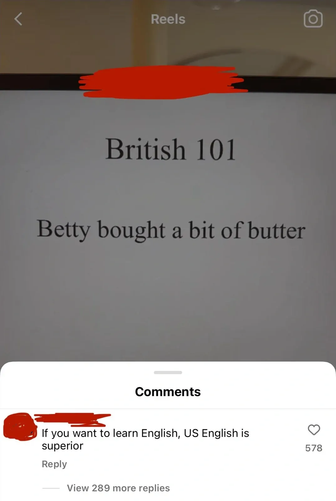 Instagram Reels screenshot. Video shows a screen/whiteboard with text "British 101" and "Betty bought a bit of butter" (username redacted at top). Comments section below: comment (username redacted): "If you want to learn English, US English is superior". View 289 more replies