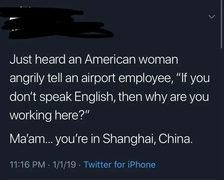Tweet with username scribbled out reading "Just heard an American woman angrily tell an airport employee, 'If you don't speak English, then why are you working here?' Ma'am... you're in Shanghai, China." 11:16 PM, 1/1/19.