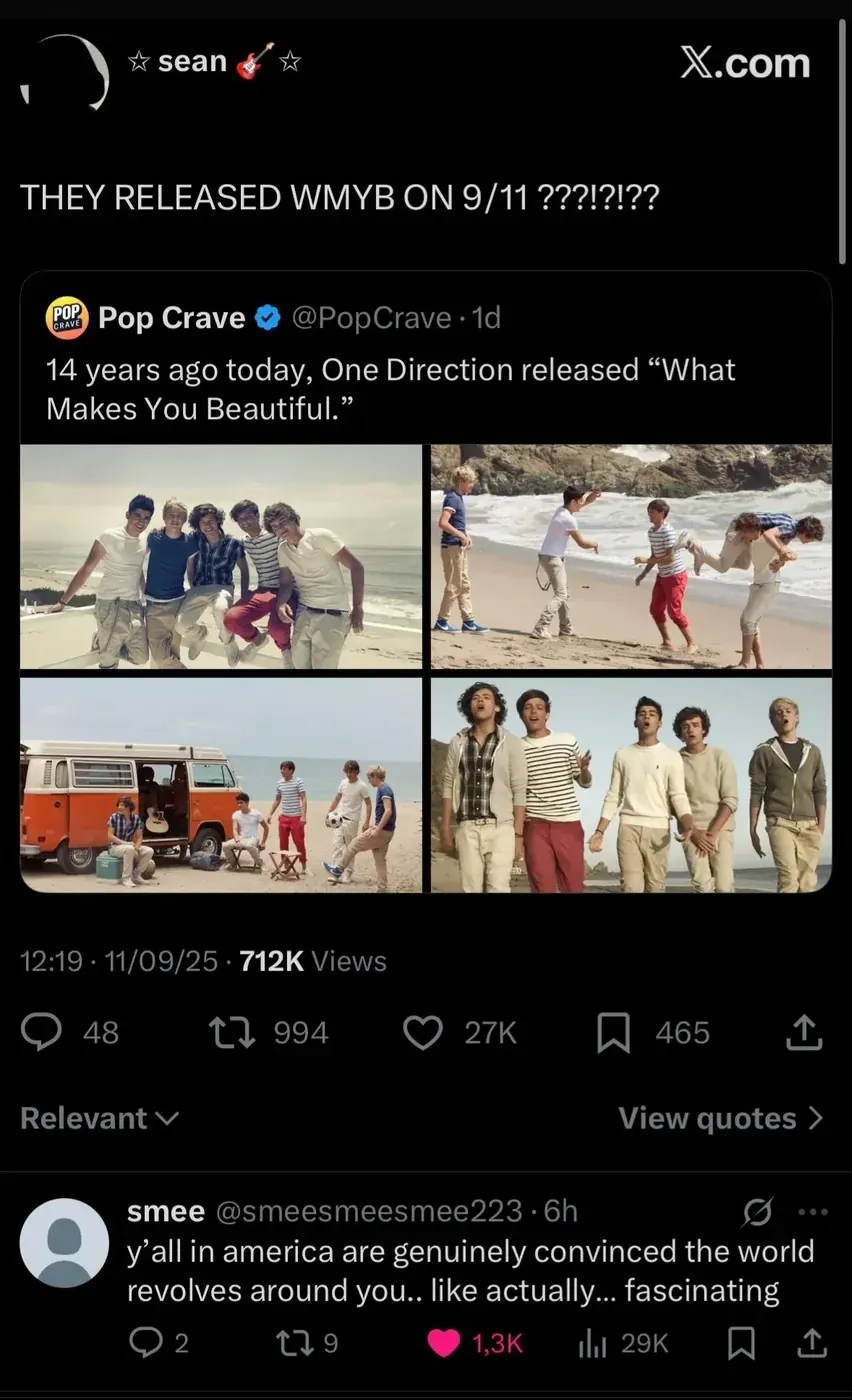 X/Twitter screenshot. @sean posts "THEY RELEASED WMYB ON 9/11??!?!??" Quote-tweeting @PopCrave (1d): "14 years ago today, One Direction released 'What Makes You Beautiful'" with two promo photos of One Direction. Reply from @smee (@smeesmeesmee223, 6h): "y'all in america are genuinely convinced the world revolves around you.. like actually... fascinating".