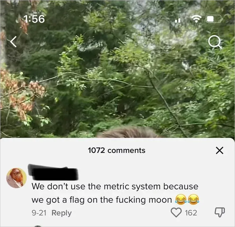 TikTok mobile. Video shows a forest/nature scene. One comment (username scribbled, 9-21): "We don't use the metric system because we got a flag on the fucking moon [two laughing-crying emojis]"