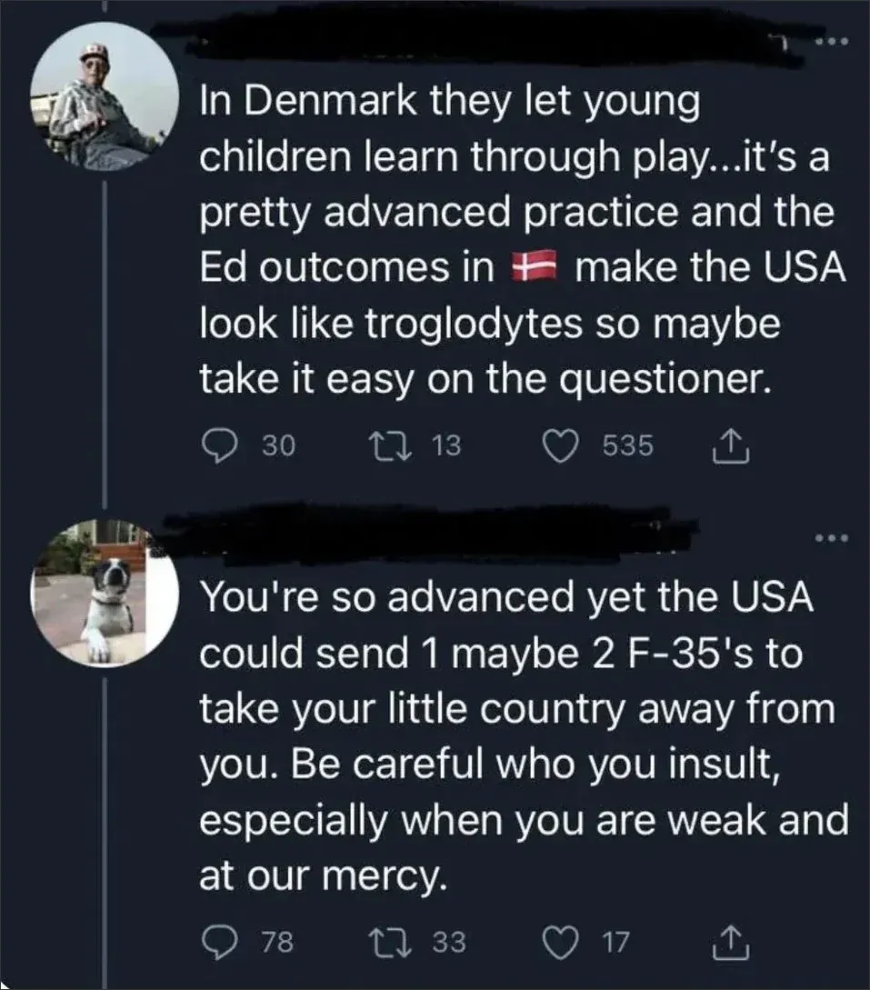 Twitter/X thread. First tweet (profile pic of person with dog, username scribbled, 14h, in Italian interface "In risposta a"): "In Denmark they let young children learn through play...it's a pretty advanced practice and the Ed outcomes in [Danish flag emoji] make the USA look like troglodytes so maybe take it easy on the questioner." Reply (profile pic of a Boston Terrier dog wearing a harness, username scribbled): "You're so advanced yet the USA could send 1 maybe 2 F-35's to take your little country away from you. Be careful who you insult, especially when you are weak and at our mercy."