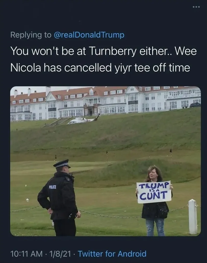 Tweet replying to @realDonaldTrump (1/8/21) - You won't be at Turnberry either.. Wee Nicola has cancelled yiyr tee off time. Photo of a woman holding a Trump is a Cunt sign on a golf course at Turnberry while a police officer looks on