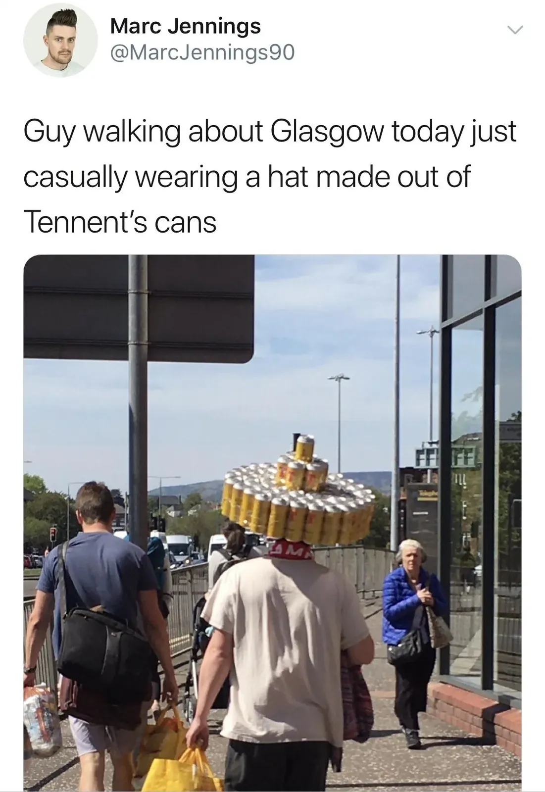 Marc Jennings @MarcJennings90 tweet - Guy walking about Glasgow today just casually wearing a hat made out of Tennent's cans. Photo of an older man on a city street wearing an elaborate tall hat constructed from gold Tennent's lager cans