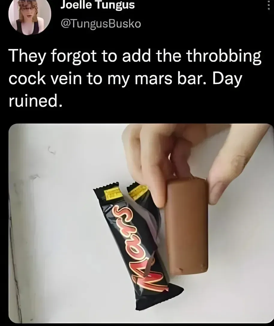 Joelle Tungus @TungusBusko tweet - They forgot to add the throbbing cock vein to my mars bar. Day ruined. Photo of a hand holding a smooth Mars bar with no ridged vein on top