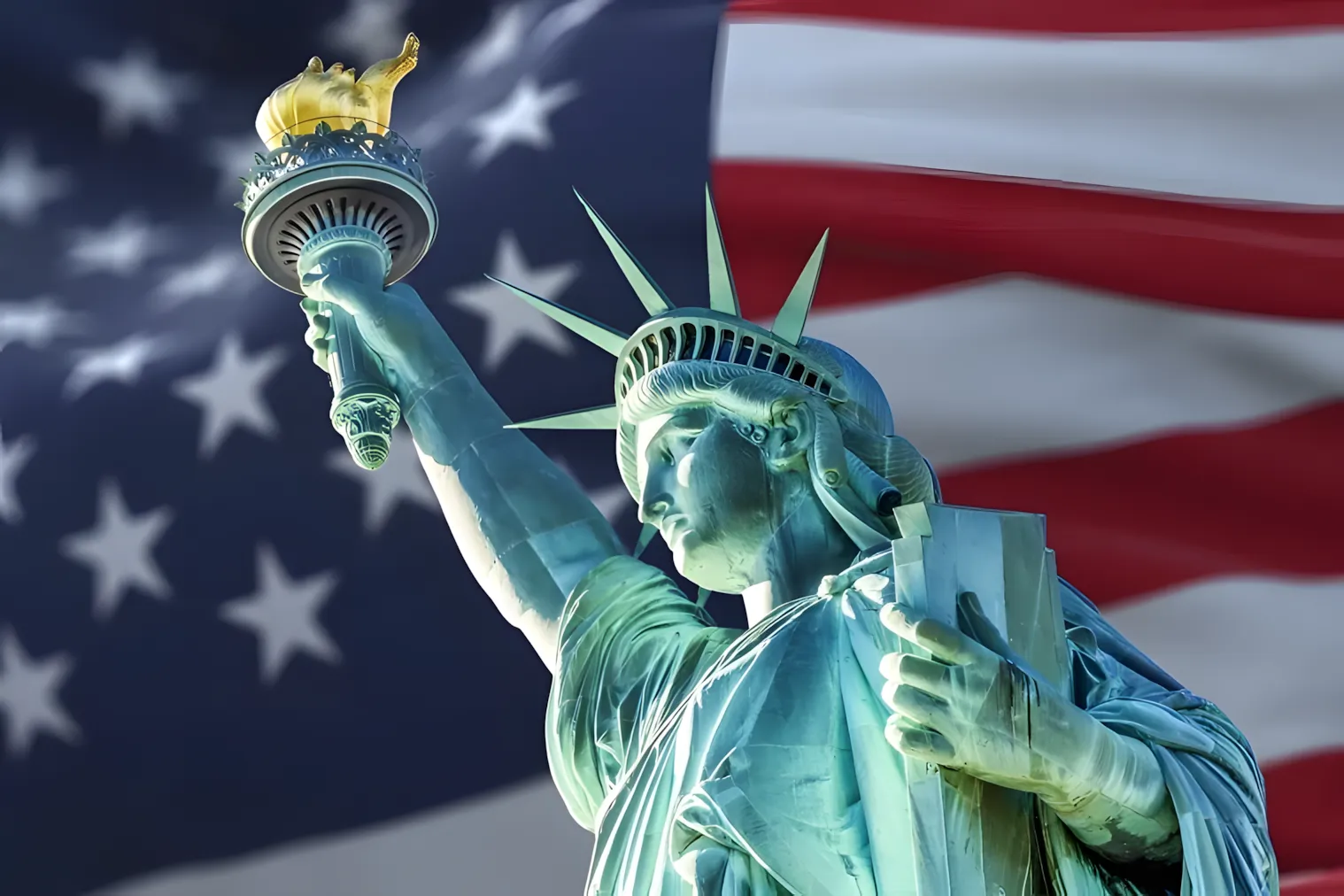 The Statue of Liberty with a large American flag billowing behind her