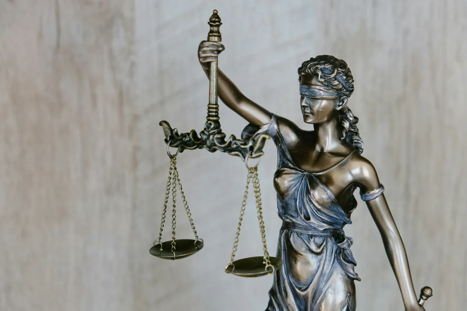 Bronze statue of Lady Justice blindfolded, holding the scales of justice aloft