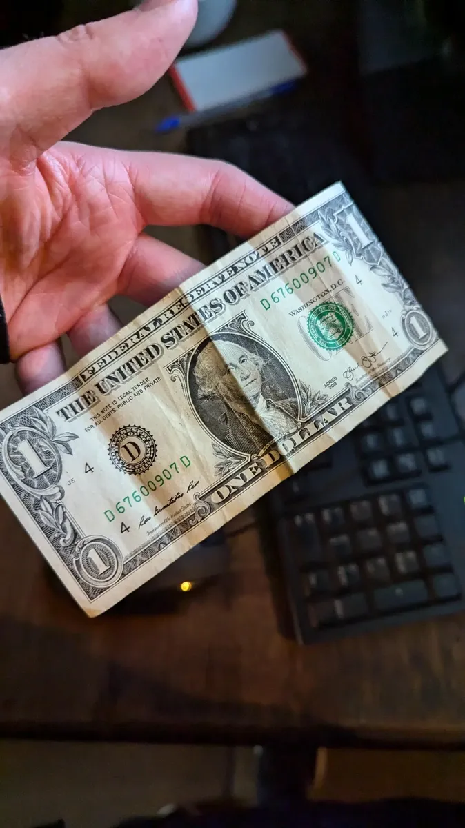 Photo of a crumpled 1 US dollar note with the caption: "Was tipped $1, I live in the UK."